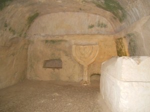 7 branched menorah next to stone coffin
